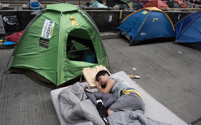 A pro-democracy protester sleeps on a street in the Mongkok district of Hong Kong on October 28, 2014. A month into the mass pro-democracy protests gripping Hong Kong, the movement is under pressure to keep up momentum -- but those on the streets say their vigil has already changed the city for good. (Nicolas Asfouri/AFP/Getty Images)