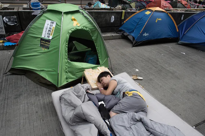 A pro-democracy protester sleeps on a street in the Mongkok district of Hong Kong on October 28, 2014. A month into the mass pro-democracy protests gripping Hong Kong, the movement is under pressure to keep up momentum -- but those on the streets say their vigil has already changed the city for good. (Nicolas Asfouri/AFP/Getty Images)