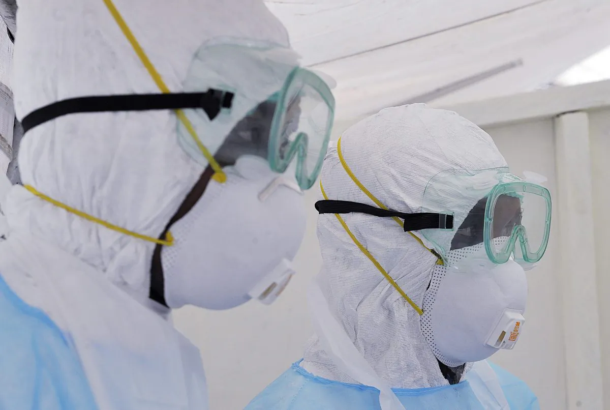 Kenyan medical workers from the Infection Prevention and Control unit wearing full protective equipment are pictured as they show on Oct. 28, 2014, how to handle an infected Ebola patient on a portable negative pressure bed at the Kenyatta national hospital in Nairobi. (Simon Maina/AFP/Getty Images)
