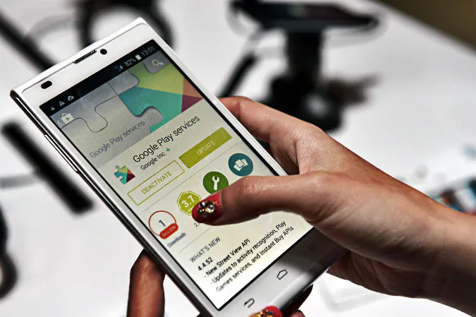 A promoter display one of the latest smart phones from ZTE, the Blade L2, using the OS Android 4.4 KitKat platform, during its launch in Singapore on Aug. 13, 2014. (Roslan
Rahman/AFP/Getty Images; effects added by Epoch Times)