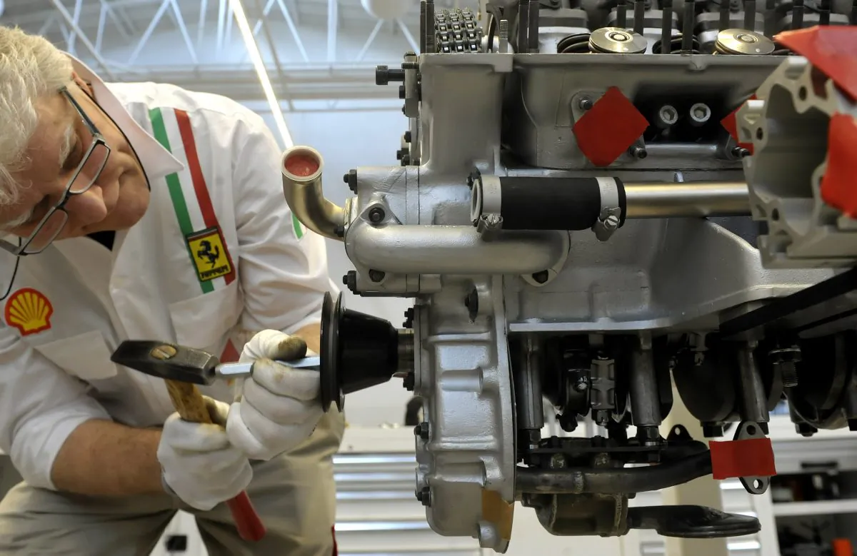 A technician works on a engine at the Ferrari plant in Maranello, Italy, on May 8, 2013. Fiat Chrysler Automobiles on Wednesday, Oct. 29, 2014 said it will spin off Ferrari into a separate company. (AP Photo/Marco Vasini)