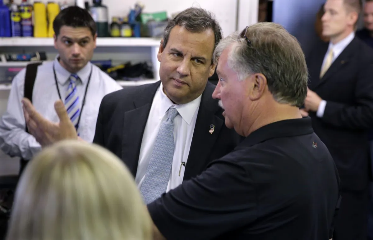 New Jersey Gov. Chris Christie (C) listens as Richard Weitzel describes repairs made to his East Dover Marina in Toms River, N.J., Wednesday, Oct. 29, 2014. Officials and residents in towns throughout coastal areas of New York and New Jersey are taking stock of the recovery from Superstorm Sandy on the second anniversary of the storm. The October 2012 storm devastated the oceanfront coastline and caused catastrophic flooding in New York and cities in New Jersey. (AP Photo/Mel Evans)