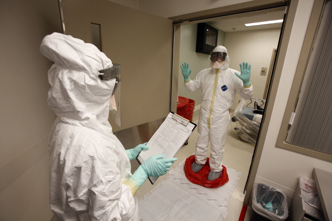 In this file photo, doctors and staff participate in a preparedness exercise on diagnosing and treating patients with Ebola virus symptoms. (AP Photo/UCLA Health System, Reed Hutchinson)