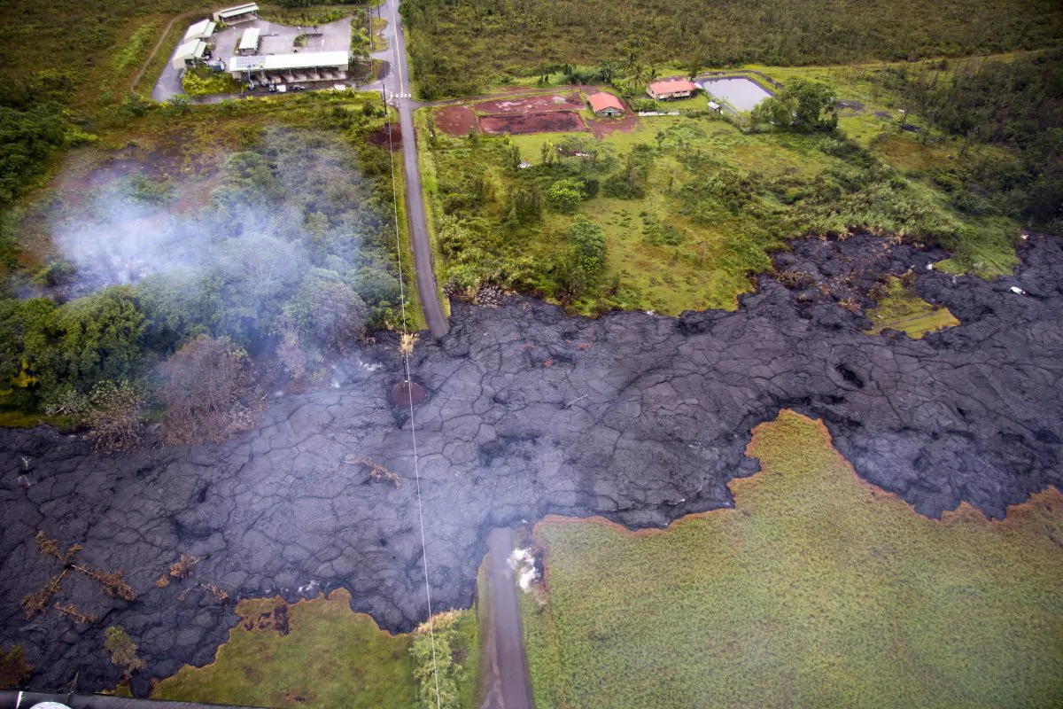 An aerial view of the lava flow over Cemetery Road near the town of Pahoa on the Big Island of Hawaii, on Oct. 29, 2014. Rain fell Wednesday on a red-hot river of lava as it threatened to consume its first home on its slow advance into a rural Hawaii town. (AP Photo/US Geological Survey)