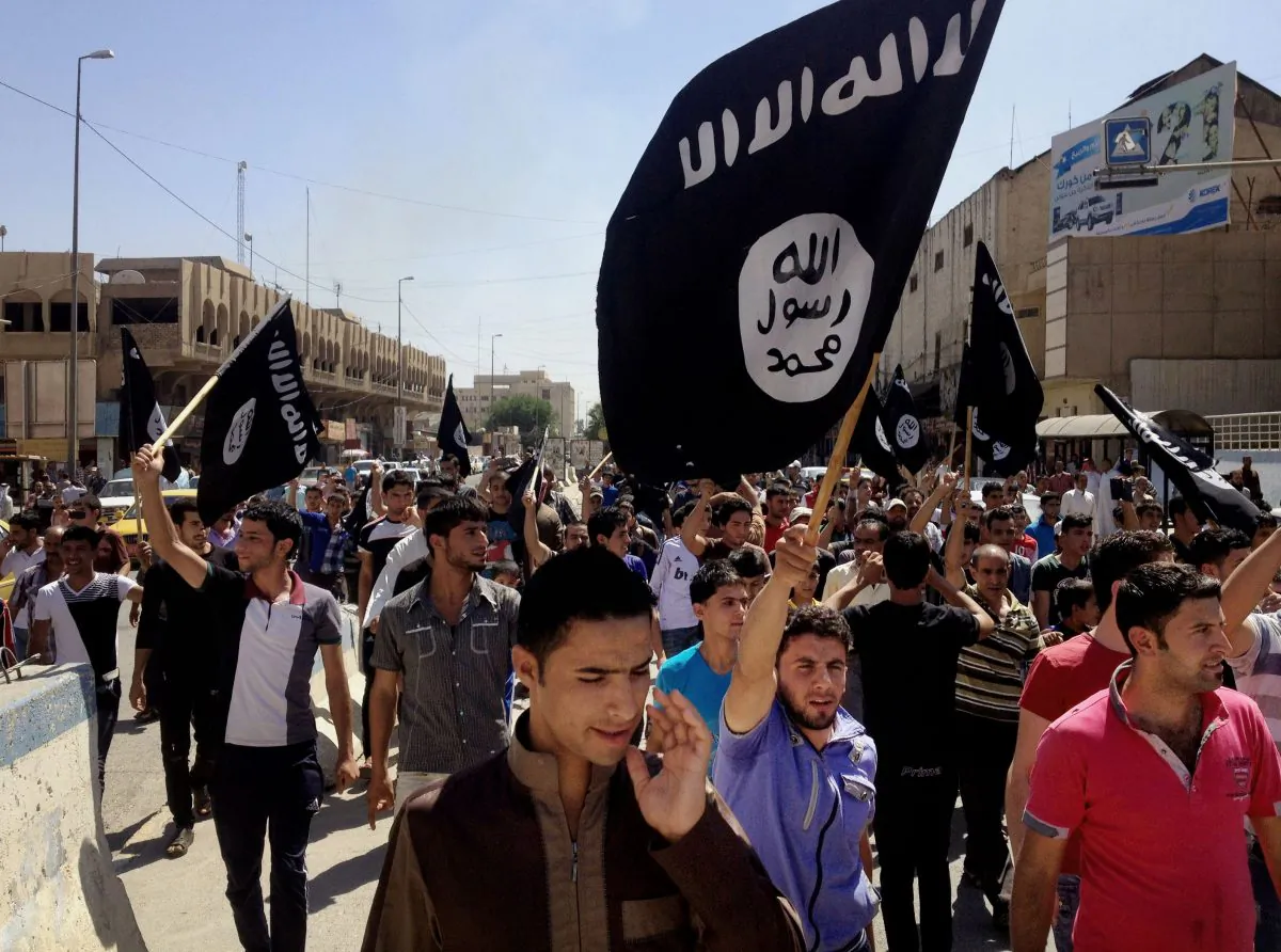 In this June 16, 2014 file photo, demonstrators chant pro-Islamic State group slogans as they carry the group's flags in front of the provincial government headquarters in Mosul. (AP Photo)