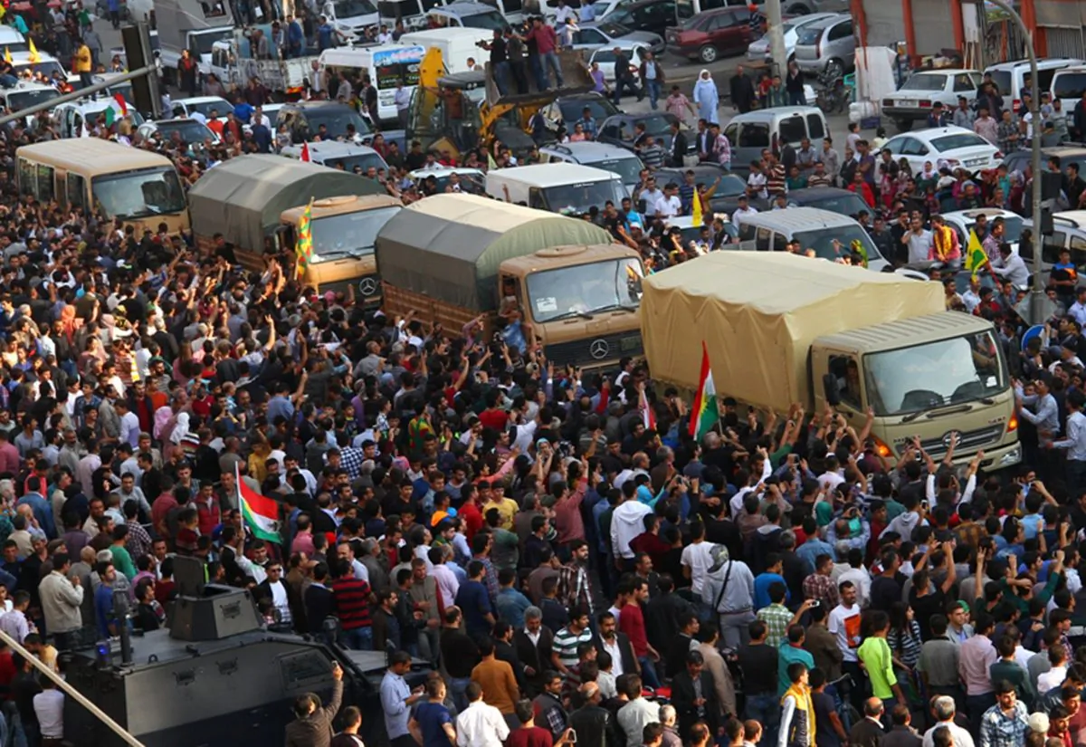 People cheer a group of Iraqi Kurdish peshmerga troops as they arrive in Mardin, southeastern Turkey, Wednesday, Oct. 29, 2014. The peshmergas are on their way to Syria to help Syrian Kurds fighting Islamic State group militants in the embattled border town of Kobani or Ayn al-Arab. (AP Photo)