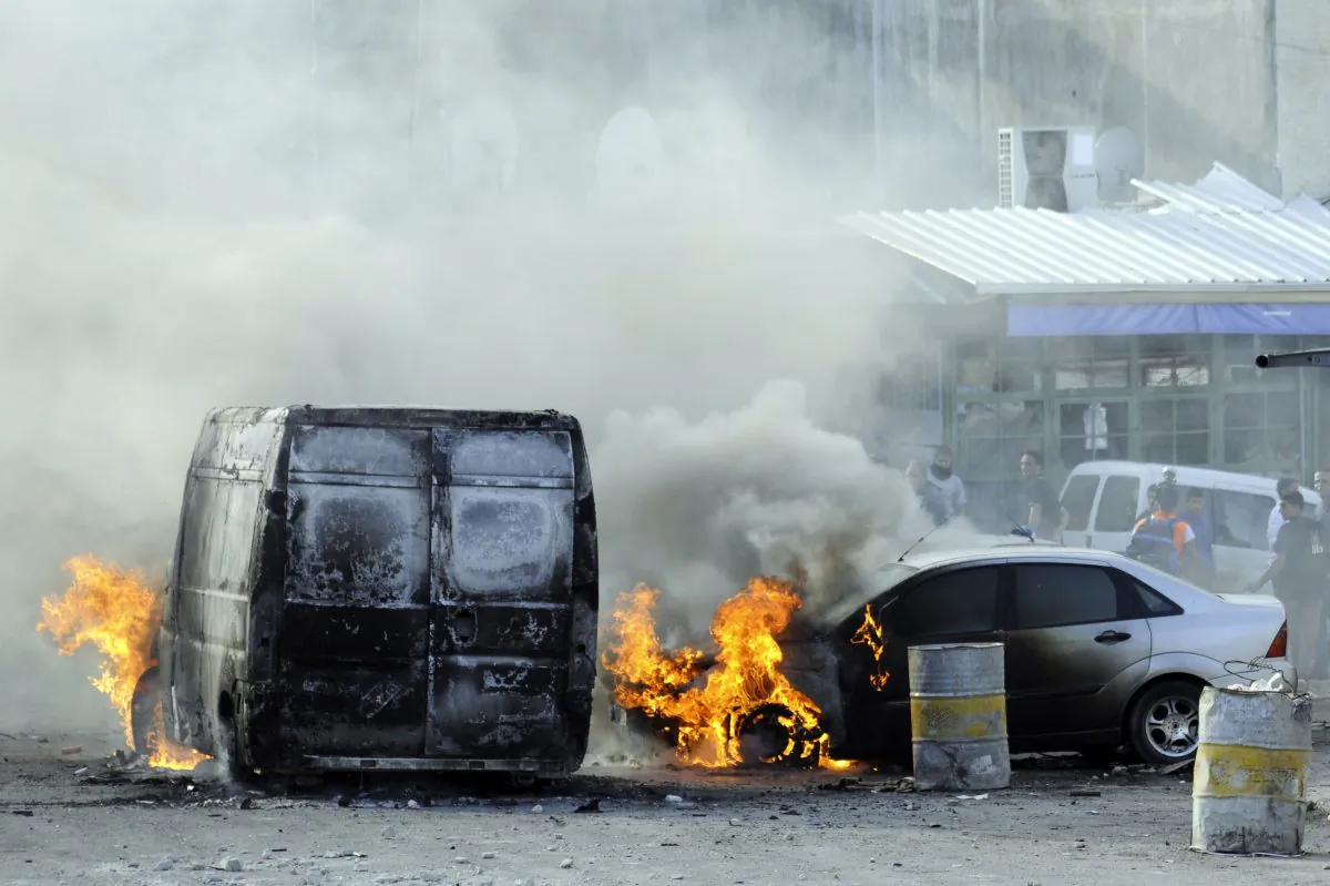 Cars are set on fire as Palestinians clash with Israeli border police after Moatez Higazi was shot in east Jerusalem Thursday, Oct. 30, 2014. Israeli police shot and killed Higazi, who was suspected of trying to kill a hard-line Jewish activist in Jerusalem, an incident that quickly sparked clashes between masked stone throwers and Israeli riot police, threatening to further enflame the already high tensions in the city. (AP Photo/Mahmoud Illean)