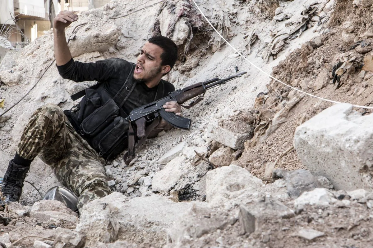 A rebel fighter calls on his comrades during clashes with regime forces in the northern Syrian city of Aleppo on Oct. 31, 2014. Syria accused Turkey on Oct. 30, of a 'flagrant violation' of its sovereignty, as Ankara allowed Iraqi Kurdish peshmerga fighters and opposition rebels to cross its border to battle jihadists. (Karam Al-Masri/AFP/Getty Images)