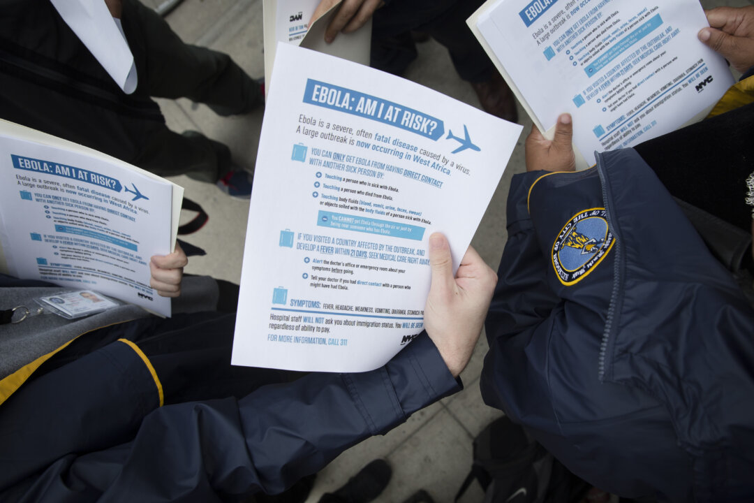 Members of the Brooklyn Borough President's office hand out fliers detailing the risks of Ebola outside The Gutter bowling alley in Brooklyn's Williamsburg neighborhood, in New York, on Oct. 24, 2014. Top medical experts studying the spread of Ebola say the public should expect more cases to emerge in the United States by years end as infected people arrive here from West Africa, including American doctors and nurses returning from the hot zone and people fleeing from the deadly disease. No one knows for sure how many infections will emerge in the US or anywhere else, but scientists have made educated guesses based on data models that weigh hundreds of variables, including daily new infections in West Africa, airline traffic worldwide and transmission possibilities. (AP Photo/John Minchillo)