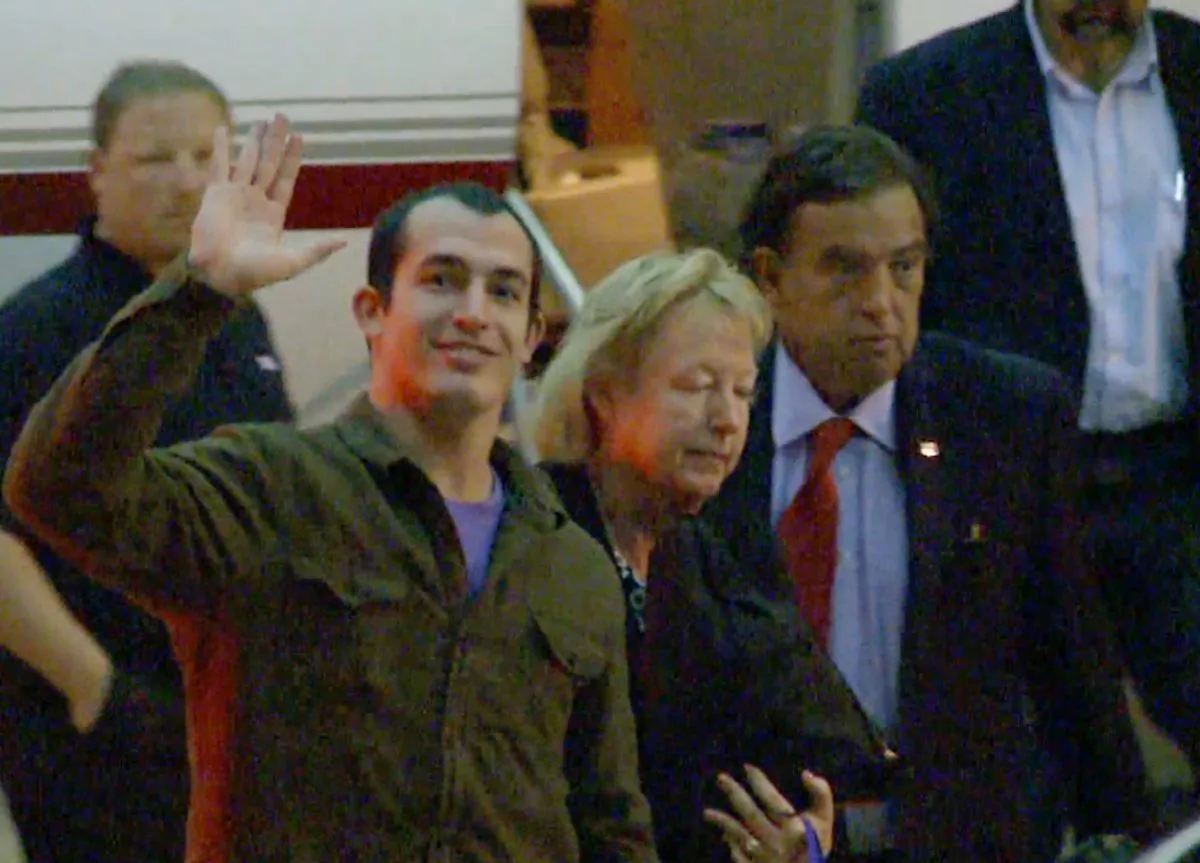 This image taken from a video shows Marine Sgt. Andrew Tahmooressi waving after arriving in Miami on Saturday, Nov. 1, 2014 in Weston, Fla. Tahmooressi is back home after a Mexican judge ordered his release from jail, where he spent eight months for crossing the border with loaded guns. Family spokesman Jon Franks told reporters that Tahmooressi arrived at a South Florida airport about 6 a.m. Saturday. Franks said Tahmooressi was resting with his family at their home suburban Weston, Fla. (AP Photo/Raul Torres)