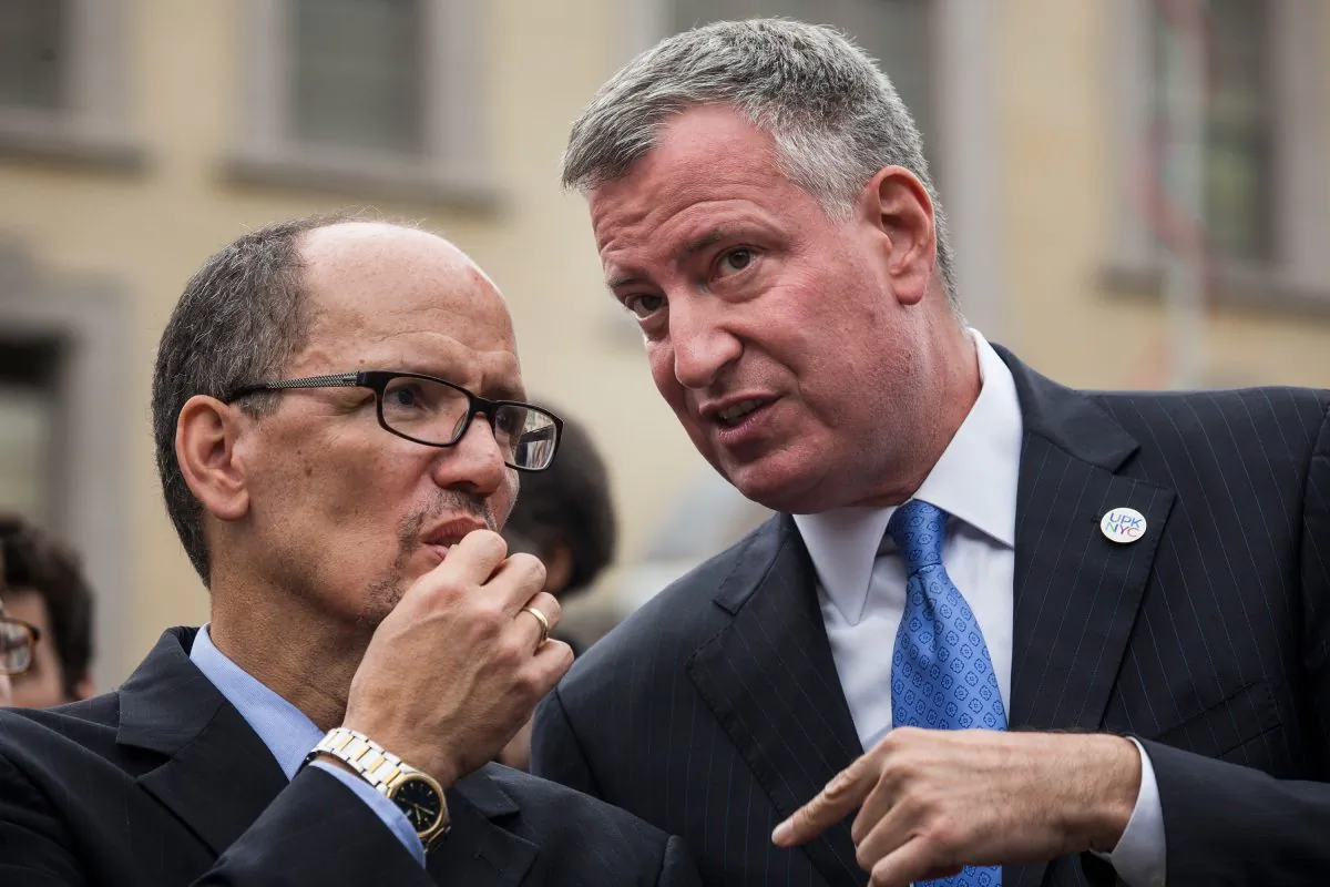  New York City Mayor Bill de Blasio (R) and Department of Labor Secretary Tom Perez speak privately at a press conference before signing an executive order raising the living wage law on September 30, 2014 in New York City (Andrew Burton/Getty Images)