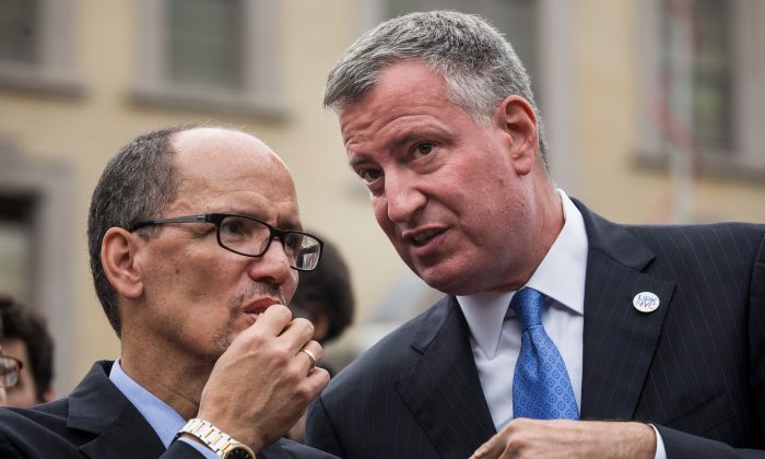  New York City Mayor Bill de Blasio (R) and Department of Labor Secretary Tom Perez speak privately at a press conference before signing an executive order raising the living wage law on September 30, 2014 in New York City (Andrew Burton/Getty Images)