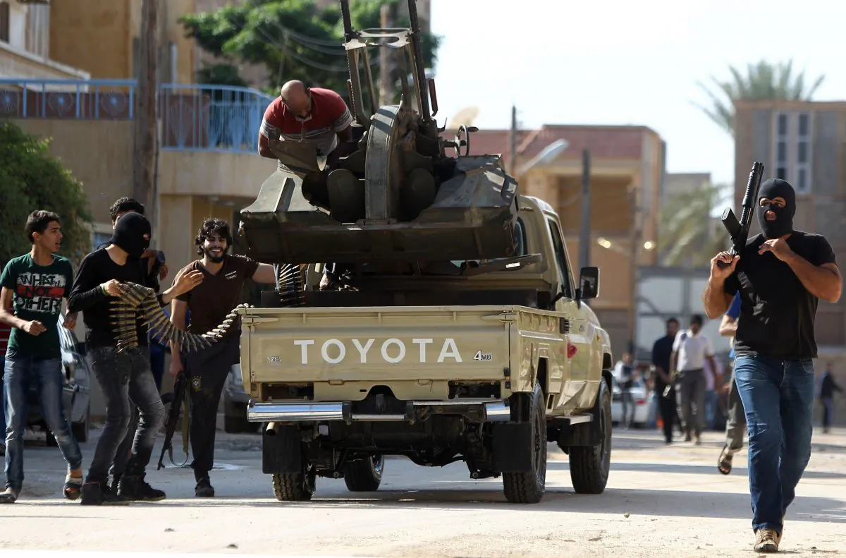 Armed civilians gather in the street during clashes with Islamist militiamen in the al-Lithi area of Libya's eastern coastal city of Benghazi on Nov. 2, 2014, after they suspected that an army personnel member who according to the civilians was kidnapped by Islamists is being hidden in the area. The previous day pro-government Libyan forces recaptured areas of second city Benghazi seized by Islamist militiamen, including army positions, military sources said as medics reported dozens killed in fighting. (Abdullah Doma/AFP/Getty Images)