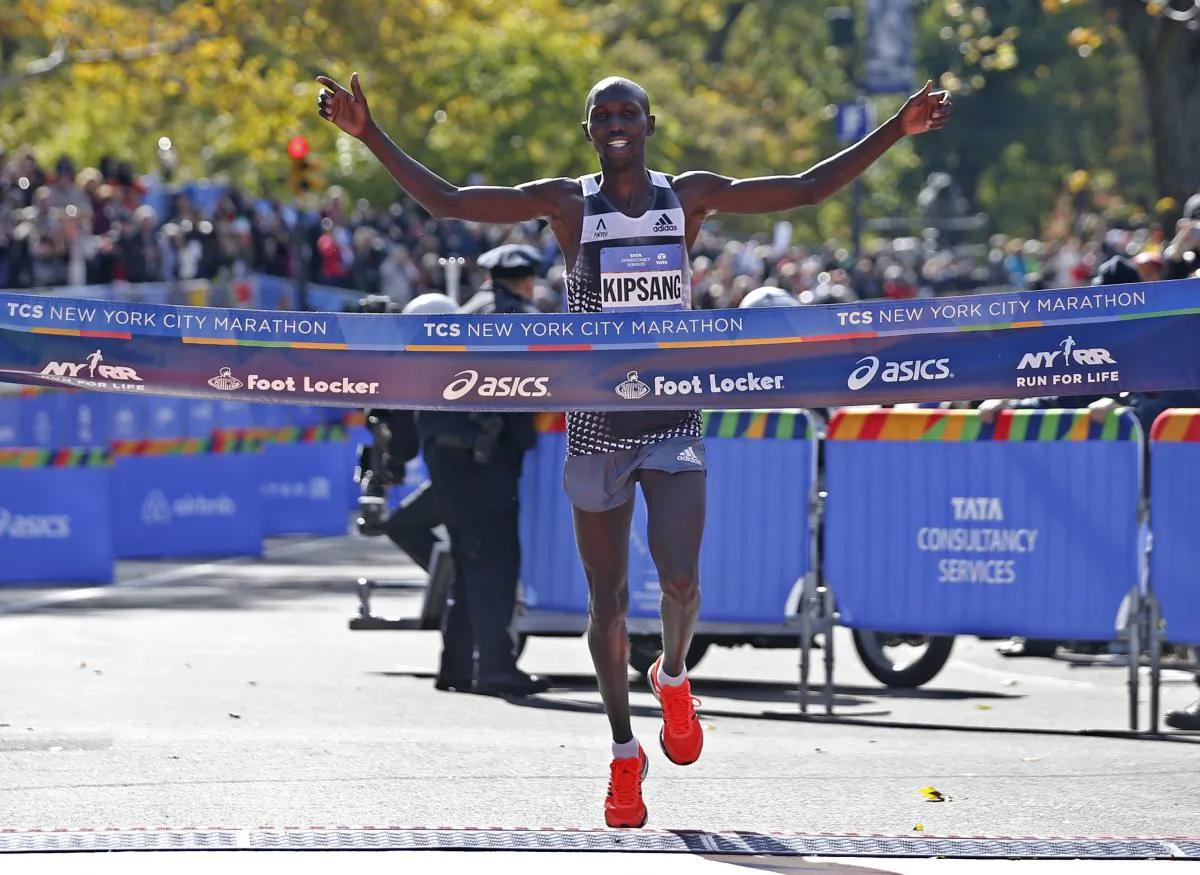 Wilson Kipsang of Kenya celebrates as he hits the tape to win the men's division of the the 44th annual New York City Marathon in New York, Sunday, Nov. 2, 2014. Kipsang won in an unofficial time of 2 hours, 10 minutes, 59 seconds. (AP Photo/Kathy Willens)