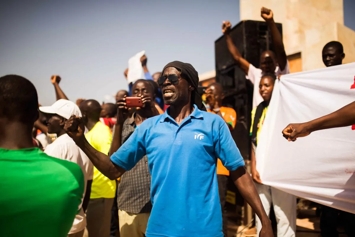 A man shouts out as he and others gather at the Place de Nation, as they ask for a civilian and democratic transition in Ouagadougou, Burkina Faso, Sunday, Nov. 2, 2014. Burkina Faso's new military leader is coming under growing pressure to hand over power to a civilian government. About 1,000 people gathered Sunday at the Place de Nation in Burkina Faso's capital. (AP Photo/Theo Renaut)
