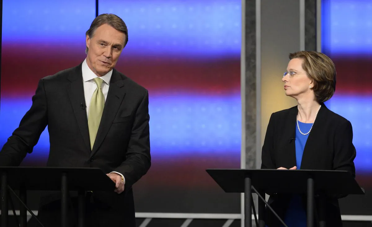 Republican Georgia US Senate candidate David Perdue (L) says Democrat Michelle Nunn is tied to President Barack Obama during an exchange in their final debate Sunday, Nov. 2, 2014, in Atlanta. Election Day is Tuesday, Nov. 4, 2014. (AP Photo/David Tulis)
