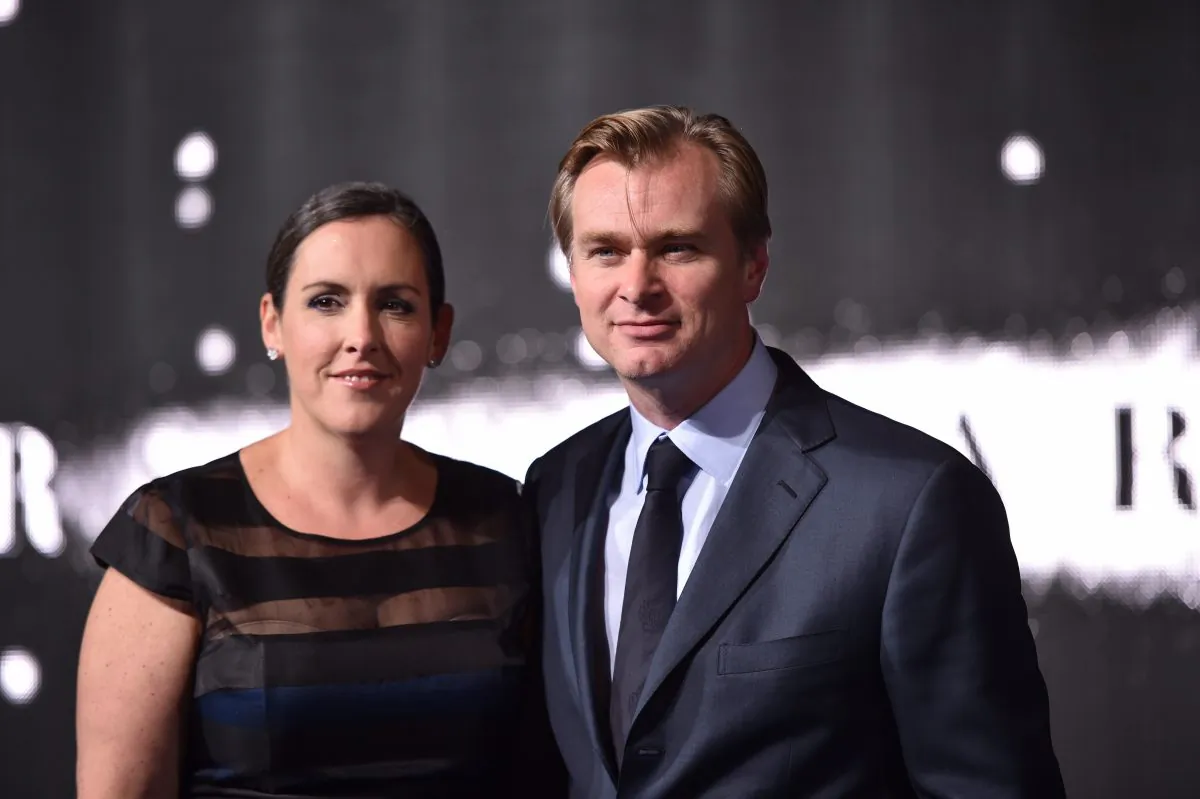 British-US director Christopher Nolan (R) poses with his wife British producer Emma Thomas (L) on the red carpet for the European premiere of the film 'Interstellar' in London on October 29, 2014. AFP PHOTO / LEON NEAL (Photo credit should read LEON NEAL/AFP/Getty Images)