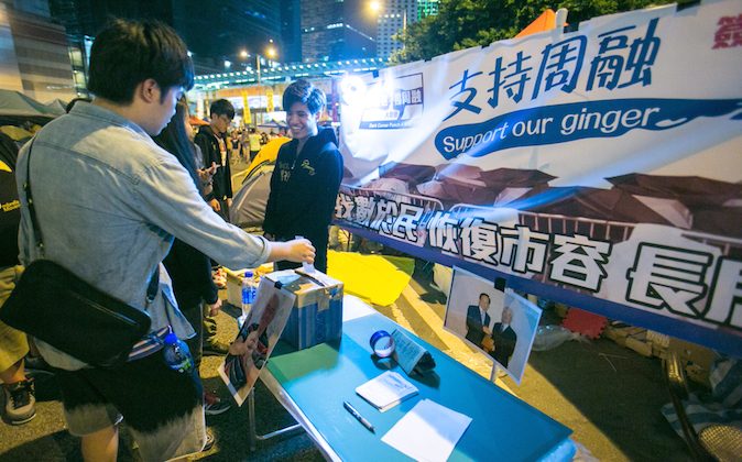 People drop in their support in a mock booth in the Central District designed to look like the Anti-occupy booth that has been around Hong Kong area on Nov. 3, 2014.  (Benjamin Chasteen/Epoch Times)