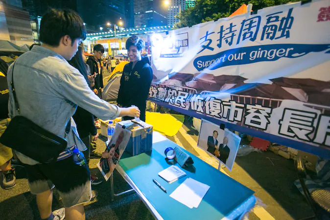 People drop in their support in a mock booth in the Central District designed to look like the Anti-occupy booth that has been around Hong Kong area on Nov. 3, 2014.  (Benjamin Chasteen/Epoch Times)