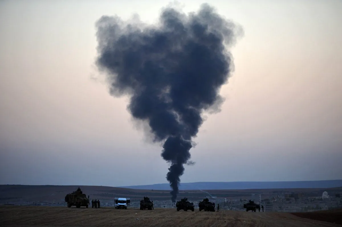 Thick smoke rises from the Syrian town of Kobani as Turkish soldiers stand guard on the Turkish side of the border during fighting between ISIL militants and Kurdish People's Protection Unit forces, as seen from the Mursitpinar crossing on the Turkish-Syrian border on Oct 26, 2014. Since mid-September, more than 200,000 people from Kobani have fled into Turkey. (Kutluhan Cucel/Getty Images)