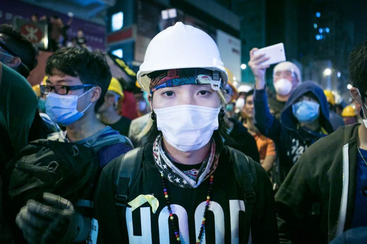 A protester wearing protective gear, is standing on the front lines of a face off between protesters and police in Mong Kok, Hong Kong, on Nov. 5, 2014. (Benjamin Chasteen/Epoch Times)