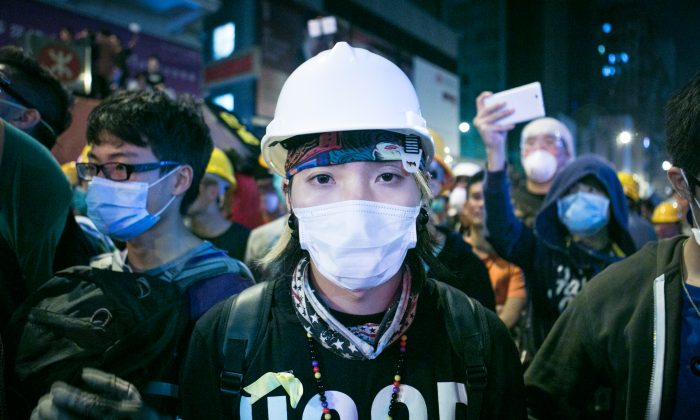 A protester wearing protective gear, is standing on the front lines of a face off between protesters and police in Mong Kok, Hong Kong, on Nov. 5, 2014. (Benjamin Chasteen/Epoch Times)