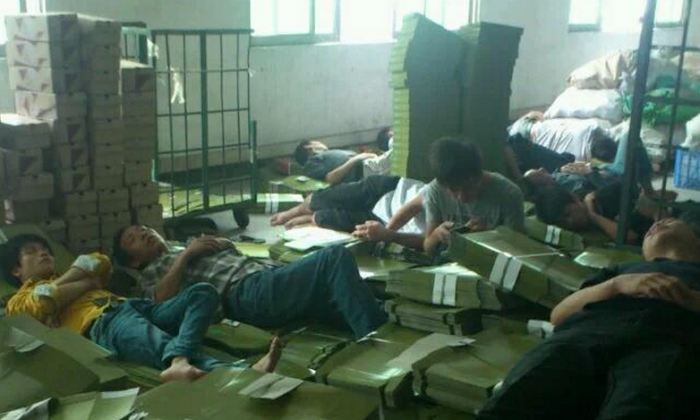 Workers at the Dongguan Xing Hong Shoe Industry sleeps on boxes at the company building in Dongguan City of Guangdong Province on Oct. 30, 2014, protesting for their salaries owed for two months. Owner of Dongguan Xing Hong has been missing for days with 700 workers unpaid for two months. (Weibo.com)