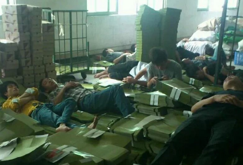 Workers at the Dongguan Xing Hong Shoe Industry sleeps on boxes at the company building in Dongguan City of Guangdong Province on Oct. 30, 2014, protesting for their salaries owed for two months. Owner of Dongguan Xing Hong has been missing for days with 700 workers unpaid for two months. (Weibo.com)