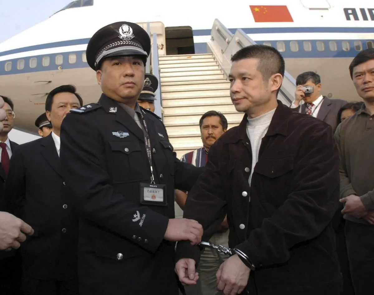 In an April 16, 2004, file photo released by China's Xinhua News Agency, Yu Zhendong, right, is arrested by Chinese police. Chinese officials have gone to great lengths to avoid capture. (AP/Xinhua, Yuan Man, File) 