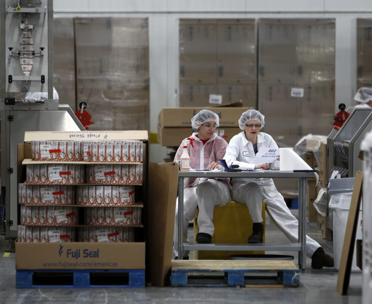 Two employees work in the sleeving plant where labels are put on containers at Chobani Greek Yogurt in South Edmeston, N.Y., on Jan. 13, 2012. New York state's upstate-downstate divide is alive and well, as Tuesday's election results showed. Cuomo has tried to appeal to upstate with talk of yogurt plants, tourism, and economic development initiatives in Buffalo but the numbers show there's still significant differences when it comes to how the two areas view state government. (AP Photo/Mike Groll)
