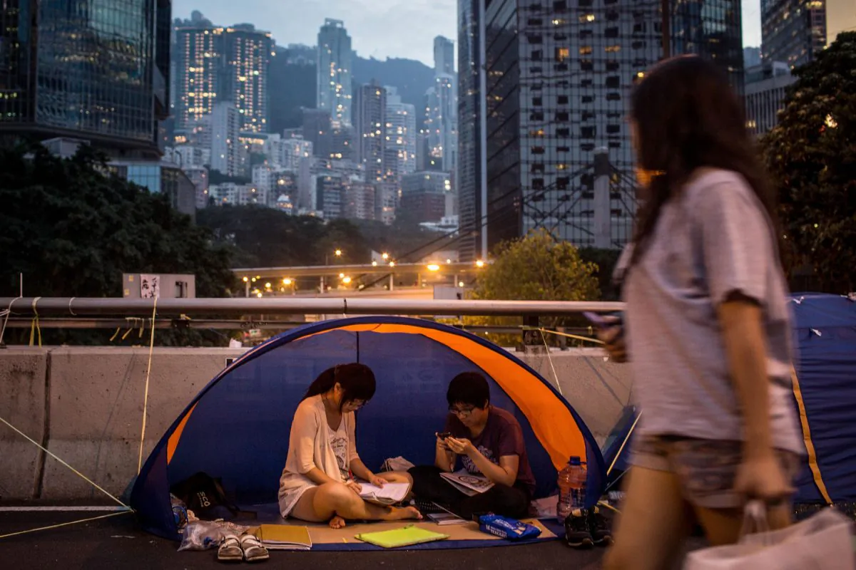 Pro-democracy activists read in a tent on a street outside Hong Kong's Government Complex on Oct. 26, 2014 in Admiralty District, Hong Kong. A student member of Hong Kong Scholarism was refused entry at the customs in the city of Shenzhen, which borders Hong Kong, on Nov. 7, 2014. (Chris McGrath/Getty Images)