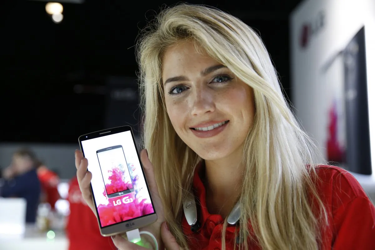 An LG employee poses for photographers holding the company's newly unveiled smartphone called the G3 at a press event in London, Tuesday, May 27, 2014. (Lefteris Pitarakis/AP Photo)