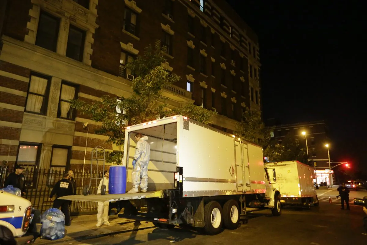 Workers from BioRecoveryCorp carry equipment from the apartment building of Ebola patient Dr. Craig Spencer in New York on Oct. 24, 2014. Spencer has been successfully treated for the virus and will be released from Bellevue hospital on Tuesday morning, city officials said. (AP Photo/Frank Franklin II)

