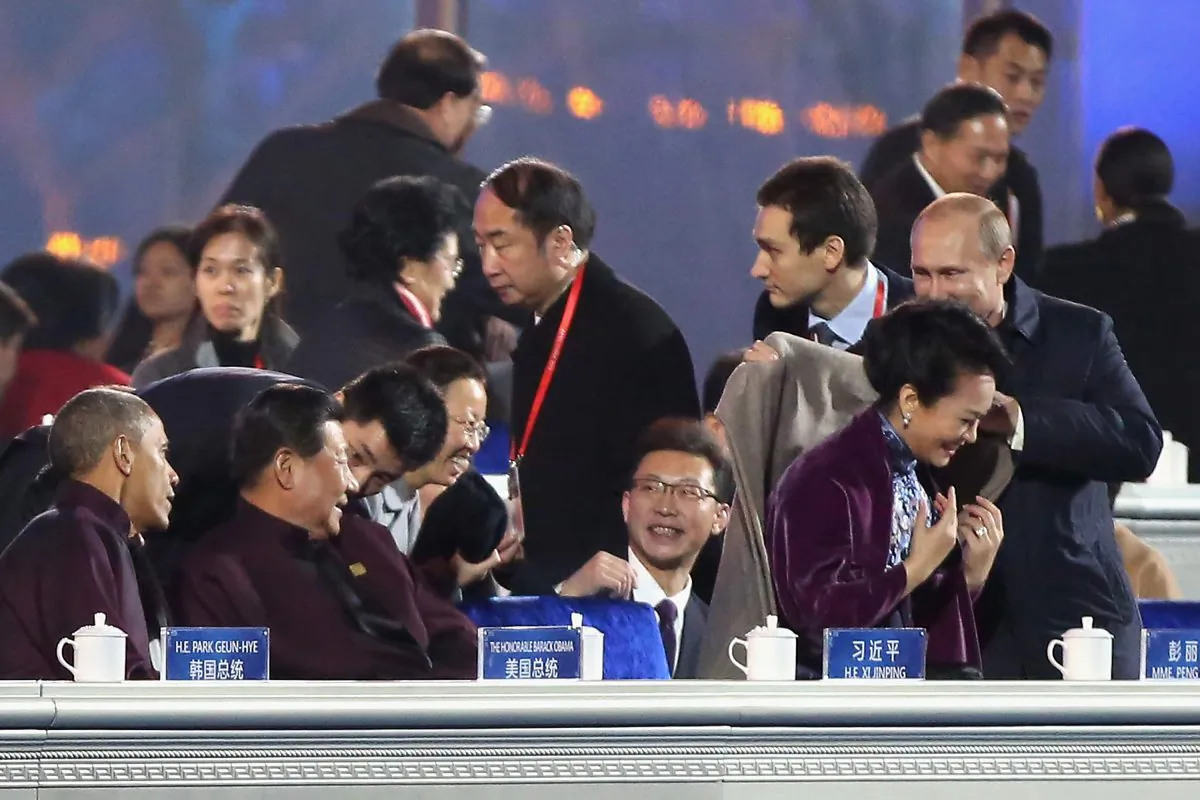 Nov. 10: Russian President Vladimir Putin (R) puts on a shawl for Chinese President Xi Jinping's wife Peng Liyuan (2nd R) while Chinese President Xi Jinping (2nd L) and U.S. President Barack Obama (L) looks them before a fireworks show after the Welcome Banquet for 2014 APEC leaders (Feng Li/Getty Images)