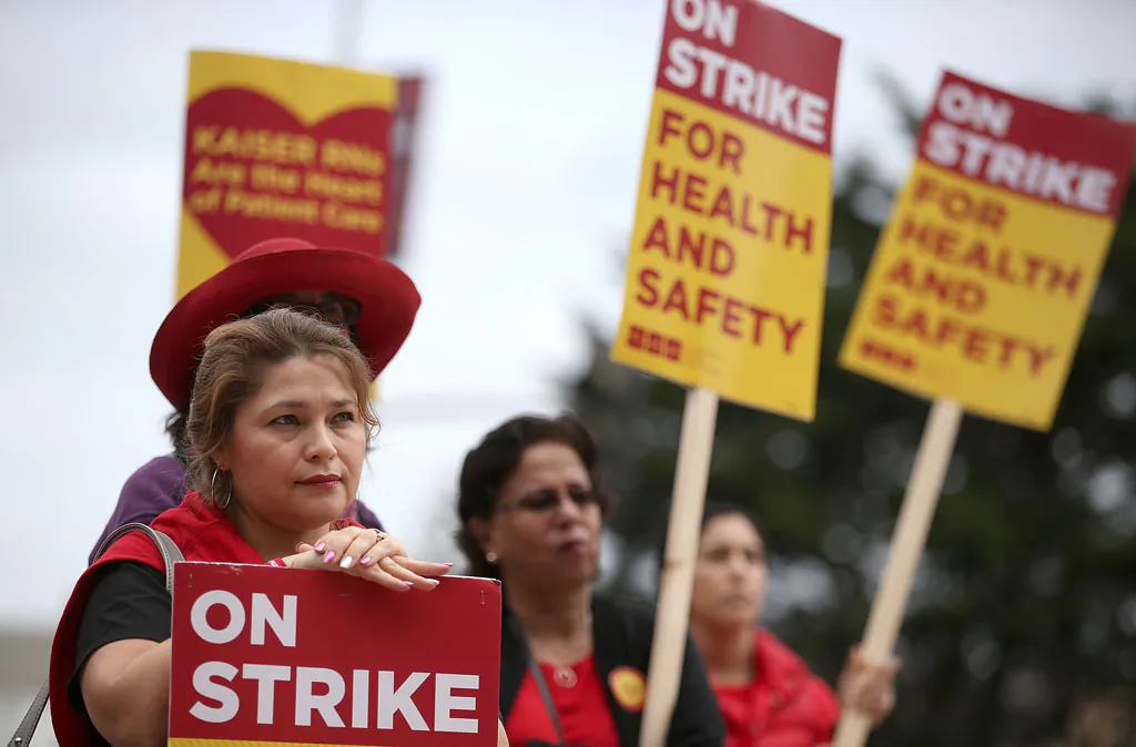 Nurses carry signs as they strike outside of Kaiser Permanente hospital on Nov. 11, 2014, in San Francisco, California. Nearly 18,000 Kaiser Permanente nurses in Northern California are staging a two-day strike amidst contract negotiations and to demand better working conditions, training and optimal safeguards for treating ebola. (Justin Sullivan/Getty Images)