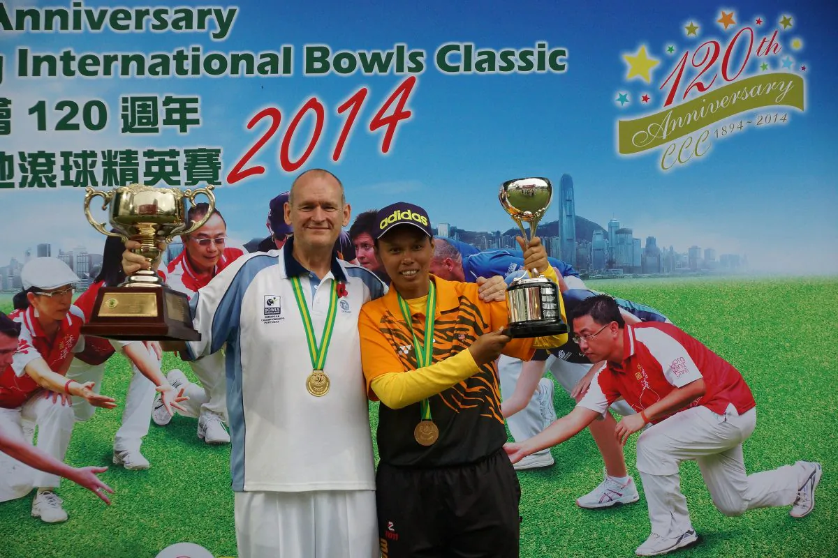 WE ARE THE CHAMPION—Scottish bowler Robert Grant (left) and Siti Zalina Ahmad from Malaysia proudly display their Hong Kong International Bowls Classic singles trophies on Sunday Nov 9, 2014. (Mike Worth)