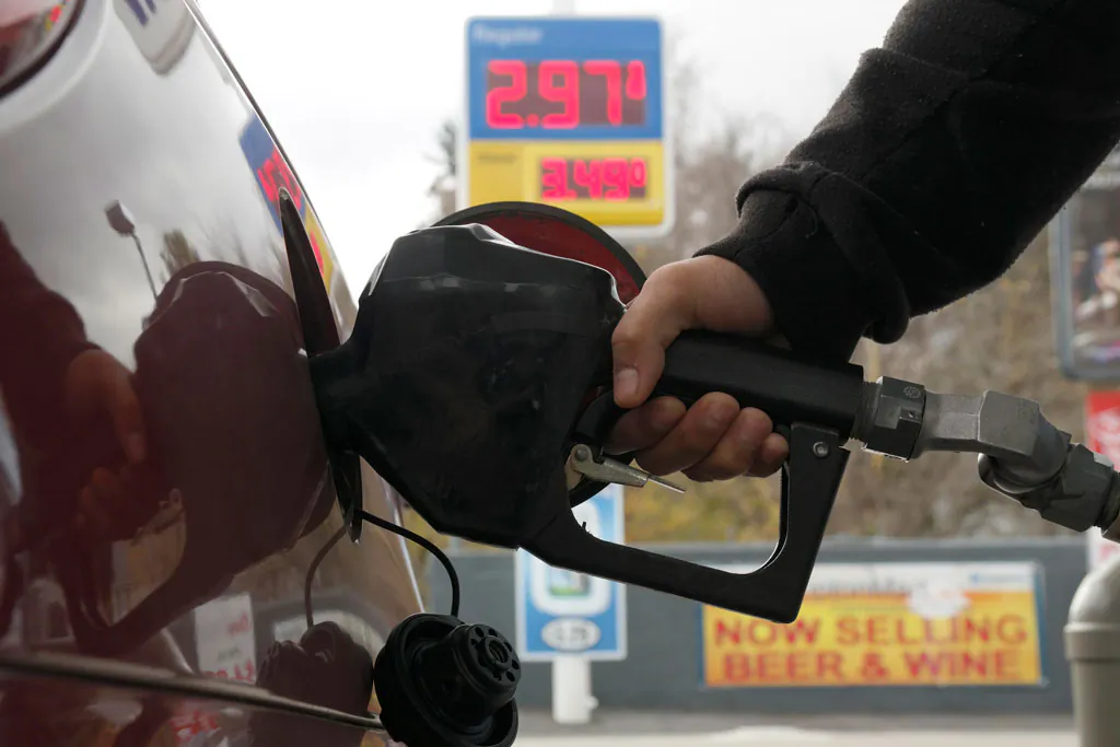 A motorist refuels at a gas station where prices have dipped below $3 per gallon, Monday, Oct. 27, 2014, in Pittsfield, Mass. A national survey of gas prices reports that the average cost of US regular grade gas dropped 18 cents per gallon in the last two weeks. (AP Photo/The Berkshire Eagle, Ben Garver)