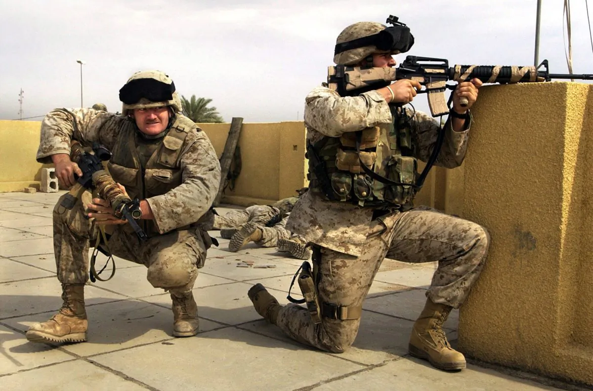 US Marine snipers from the 2nd Battalion, 5th Marine Regiment, take cover during a gun battle with insurgents in Ramadi in Anbar province, Iraq, on Oct. 31, 2004. (AP Photo/Jim MacMillan)