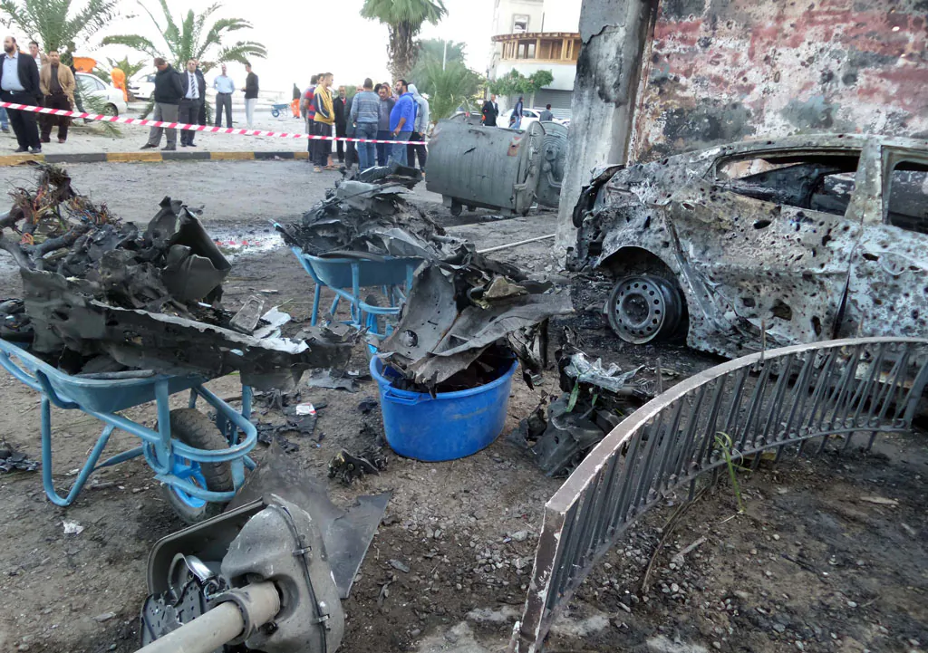 Libyans stand at the scene of car bomb explosion which targeted the compound of the Egyptian embassy in the Libyan capital Tripoli on Nov. 13, 2014. (Mahmud Turkia/AFP/Getty Images)