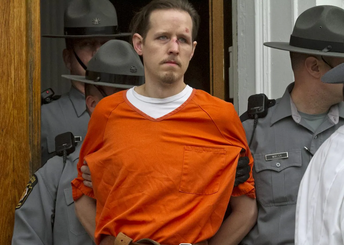 Eric Frein, charged with the murder of Pennsylvania State Trooper Cpl. Byron Dickson and critically wounding Trooper Alex Douglass, is taken to prison after a preliminary hearing in Pike County Courthouse in Milford, Pa., on Oct. 31, 2014. On Thursday, Nov. 13, 2014, authorities added terrorism charges againstFrein and they say he told them he wanted to "wake people up." State police say Eric Frein called slaying of Cpl. Bryon Dickson an "assassination" in an interview after his capture. (AP Photo/The Scranton Times-Tribune, Michael J. Mullen)