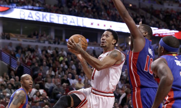 Chicago Bulls guard Derrick Rose drives past Detroit Pistons forward Greg Monroe (10) during the second half of an NBA basketball game Monday, Nov. 10, 2014, in Chicago. The Bulls won 102-91. (AP Photo/Charles Rex Arbogast)