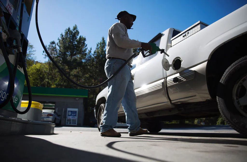 Motorist Jerry Reed fills up his tank at a gas station in Atlanta on Oct. 30, 2014. Almost unbelievably, the national average price of a gallon of gasoline is back under $3 for the first time since Dec. 2010. (AP Photo/David Goldman)