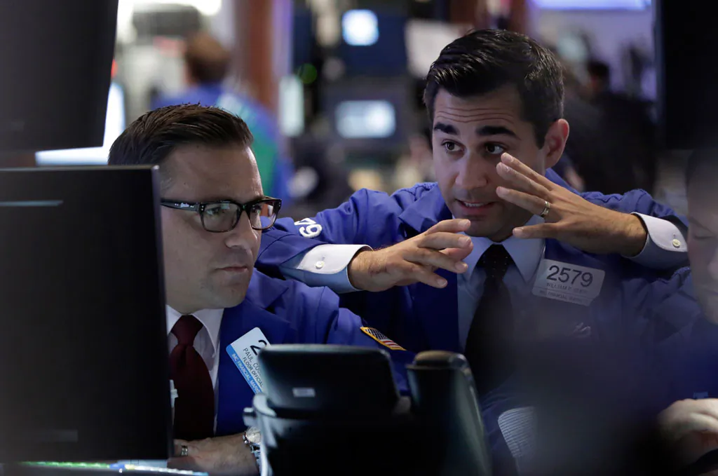 Specialists Paul Cosentino (L) and William Geer work at a post on the floor of the New York Stock Exchange, Thursday, Oct. 16, 2014. US stocks drifted between small gains and losses in late afternoon trading Thursday, struggling to remain in positive territory after a steep slide early in the day. (AP Photo/Richard Drew)