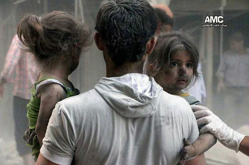 A Syrian man helping children out of a damaged building following a Syrian government airstrike in the Shaar neighborhood of Aleppo, Syria, on July 9, 2014. Despite being battered by a war, now in its fourth year, the country is still firmly under the grip of President Bashar Assad despite an armed rebellion to uproot him and losing territory to opposition rebels and the extremist Islamic State group. (AP Photo/Aleppo Media Center-AMC)