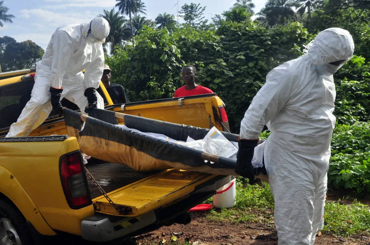 Health workers unload the lifeless body of a man suspected of contracting the Ebola virus, as they carry him to a grave site on the outskirts of Monrovia, Liberia, on Oct. 27, 2014. Health officials in the US and Europe are scrambling to begin testing a handful of experimental Ebola drugs in Africa, but an ethical debate is brewing over how to appropriately test medicines amid an outbreak that has already killed nearly 5,000 people. (AP Photo/Abbas Dulleh)
