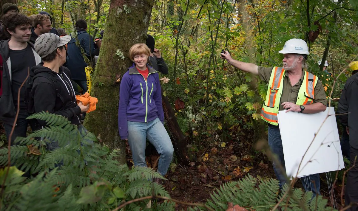 A Kinder Morgan worker with the Trans Mountain Pipeline expansion project records protesters on Burnaby Mountain after they forced the work crew to leave on Oct. 29, 2014. The pipeline issue has made its way into the Vancouver area municipal election campaigns. (The Canadian Press/Darryl Dyck)