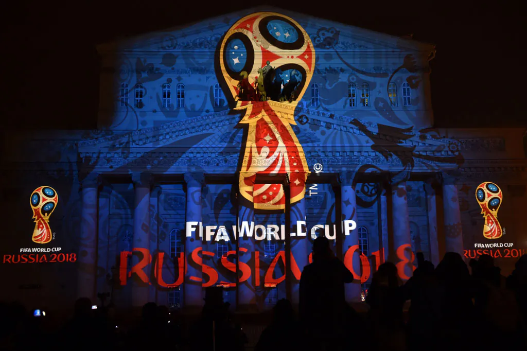 People watch as the facade of the historical Bolshoi Theatre is illuminated with the official emblem of the 2018 FIFA World Cup to be held in Russia in central Moscow on late Oct. 28, 2014. World football boss Sepp Blatter on Tuesday opposed any boycott of the 2018 World Cup in Russia and backed the huge preparations undertaken by President Vladimir Putin's government for the mega event. (Kirill Kudryavtsev/AFP/Getty Images)