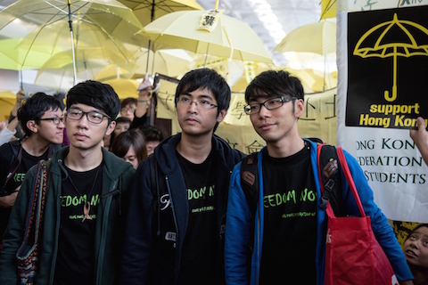 Student leaders Alex Chow (C), Nathan Law (L) and Eason Chung (R) are surrounded by pro-democracy protesters at the Hong Kong international airport before their scheduled flight to Beijing on November 15, 2014. Pro-democracy protest leaders say they will head to Beijing in hopes of bringing their demands for political reform to Chinese authorities. (Alex Ogle/AFP/Getty Images)