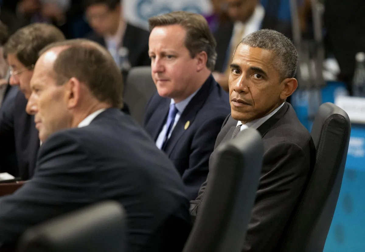 U.S. President Barack Obama, right, looks away as Prime Minister of Australia Tony Abbott, left, address a plenary session while British Prime Minister David Cameron looks on during the G-20 summit in Brisbane, Australia, Saturday, Nov. 15, 2014. (AP Photo/Rob Griffith,Pool)