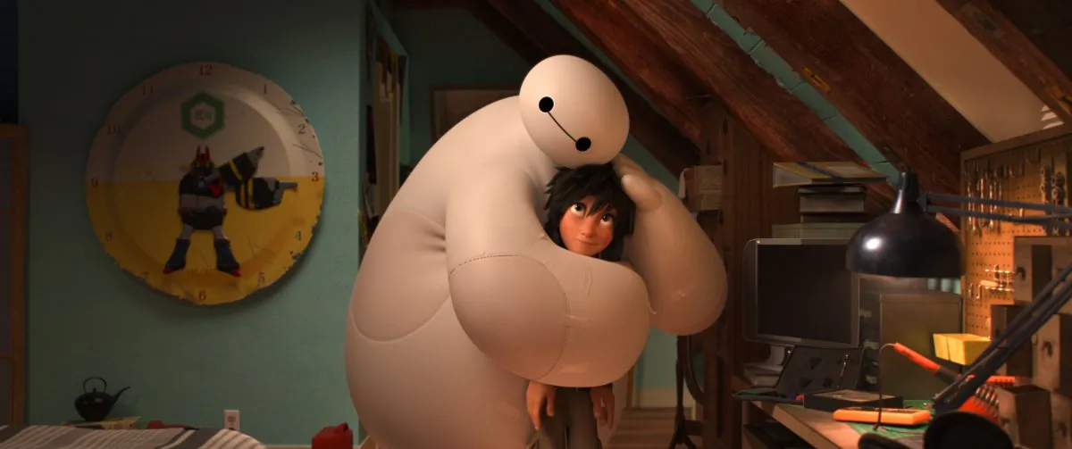 Baymax, voiced by Scott Adsit, gives Hiro Hamada, voiced by Ryan Potter, a hug in “Big Hero 6.” (AP Photo/Disney)